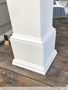 a white pillar is sitting on the ground in front of a house with wood flooring