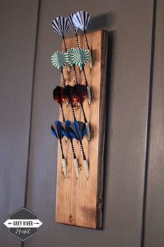 a wooden wall hanging with several different types of hair brushes on it's side