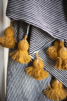 black and white striped fabric with yellow tassels hanging from it's side