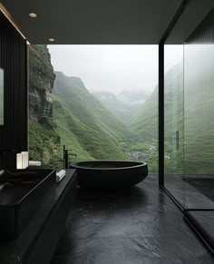 a large black bathtub sitting in the middle of a bathroom next to a window