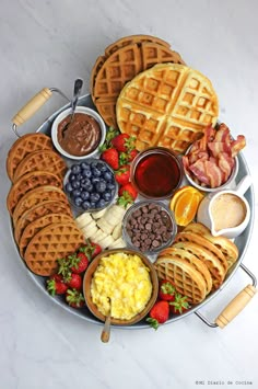 a platter filled with waffles, fruit and other foods