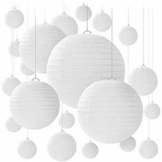 white paper lanterns hanging from strings on the ceiling in front of a white backdrop with balls