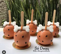 there are four cake pops with bones and bones on them in the shape of apples