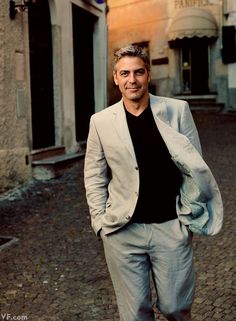 a man standing in the middle of an alley way wearing a suit and black shirt