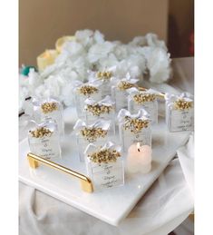 there are many small bags with gold and white decorations on them sitting on a tray