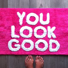 someone standing in front of a pink rug that says you look good