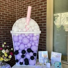 an ice cream cart with balloons in it on a table next to flowers and cards