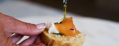 someone is dipping cheese onto a piece of bread