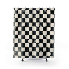 a black and white checkered shower curtain hanging on a metal rod with casteors