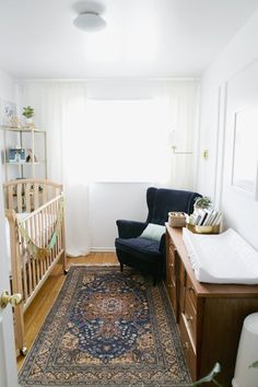 a baby's room with a crib, chair and rug