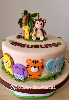 there is a cake with animals on it and the name mogulito written in spanish