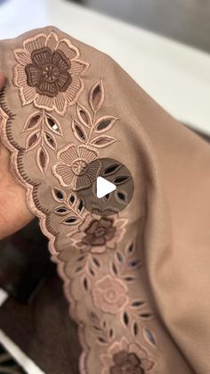 a woman is holding her purse with an appliqued flower design on it