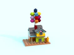 a toy house with balloons on top of it