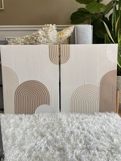 a living room with white rugs and decorative wall panels on the walls, along with a plant