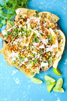 mexican food with corn, cheese and cilantro on a blue surface