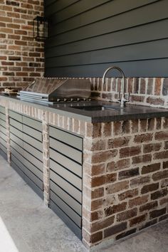 an outdoor kitchen made out of brick and steel