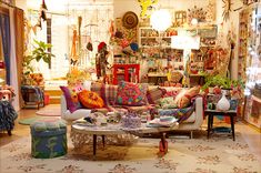 a living room filled with lots of furniture and decor on top of a white rug