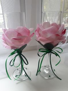 two clear vases with pink flowers in them