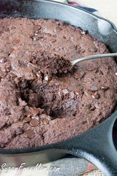 a chocolate cake in a pan with a spoon