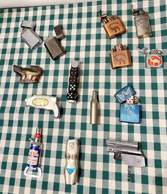 several different types of lighters on a checkered tablecloth with other items around them