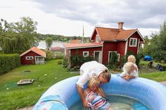 two children are playing in an inflatable pool with their mother and father nearby