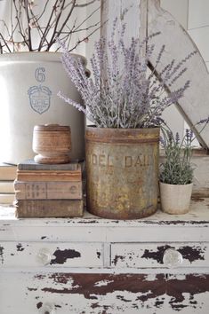 an old tin can with lavenders and books on a shelf next to a white bucket