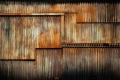 an old rusty metal wall with some rusted paint on the walls and wood slats