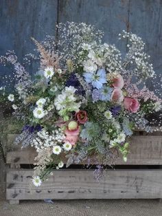 a bouquet of flowers sitting on top of a wooden crate