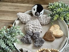 a crocheted stuffed animal sitting on top of a table next to some plants