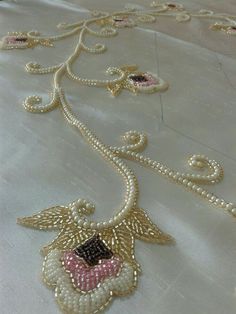 a close up of a white table cloth with gold beading and an angel motif