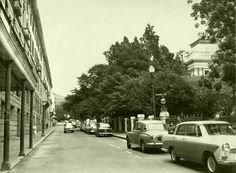 an old black and white photo of cars parked on the street