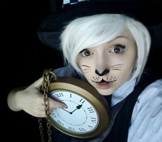 a person with white hair wearing a cat mask and holding a clock