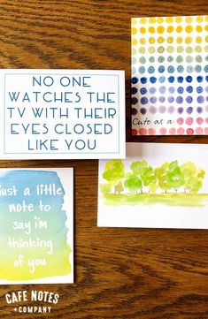 four cards with different sayings on them sitting on a wooden table next to each other