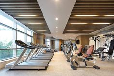 there are many treadmills in the gym with windows on both sides and floor to ceiling windows