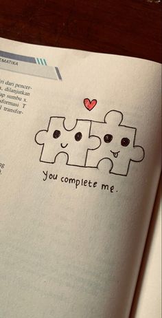 an open book with two pieces of puzzle on the page and text that reads, you complete me