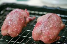 two raw meats sitting on top of a grill