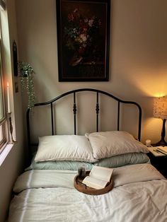 a bed with white sheets and pillows next to a window