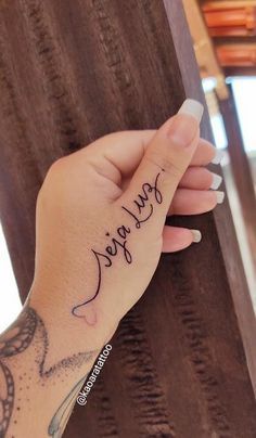 a woman's hand with a small tattoo on it