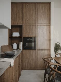 a kitchen with wooden cabinets and an oven in the center, next to a dining room table