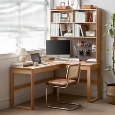 a desk with a laptop computer on top of it next to a book shelf filled with books