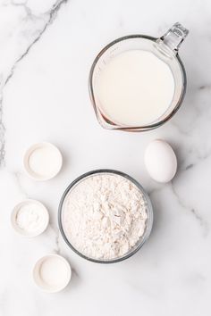 eggs, milk and flour in bowls on a marble counter