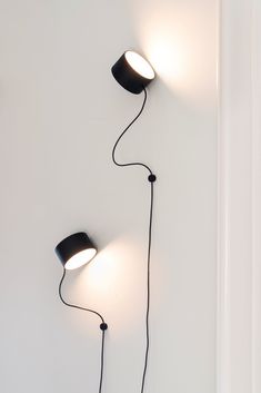 two black lamps are on the wall next to each other