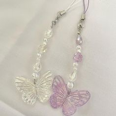 two butterflies are attached to some glass beads