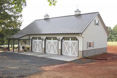 two story barn with metal roof and white doors