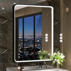 a bathroom sink with a large mirror above it and a vase filled with flowers on the counter