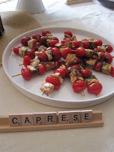 a plate full of kebabs with the word caprese spelled on it