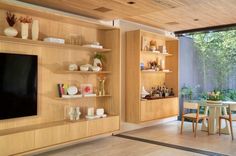 a living room filled with furniture and a flat screen tv sitting on top of a wooden shelf