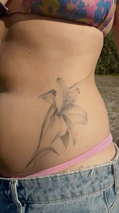 a woman's stomach with a flower tattoo on her lower body and bottom part