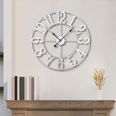 a clock that is on the wall next to a vase with flowers and books in front of it