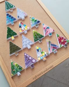 a wooden table topped with lots of colorful christmas trees